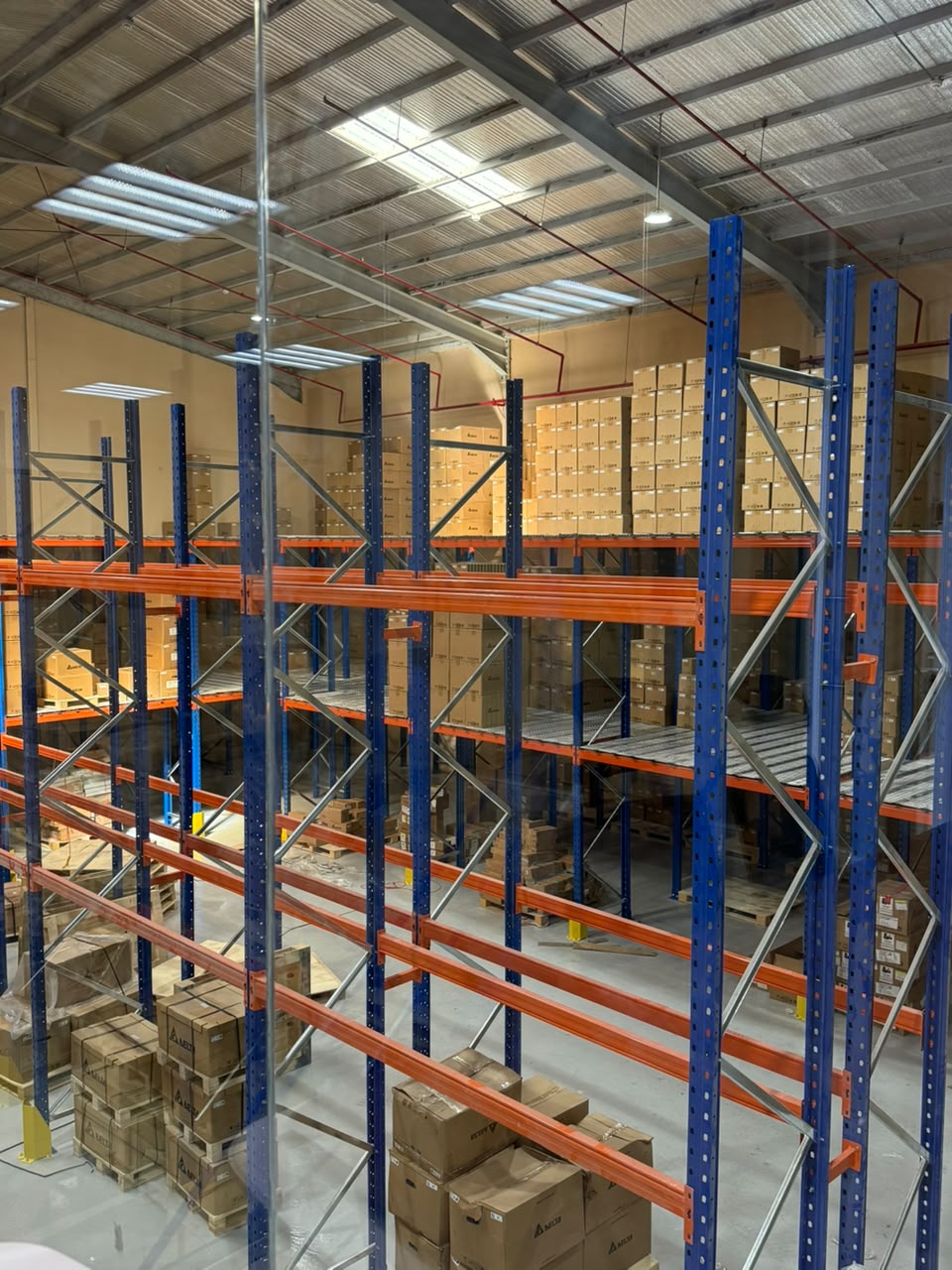 Delta VFD drives and PLC boxes stacked on racking inside the Tesla Automation warehouse in Riyadh, Saudi Arabia